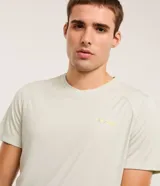 Remera deportiva color verde claro, de corte regular, con cuello redondo y mangas cortas. Presenta un pequeño estampado con letras en el pecho y un recorte en la espalda.