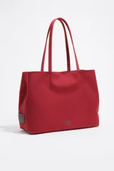 Bolso shopper de tamaño grande confeccionado en nylon, con estructura blanda, doble asa de hombro y logo metálico frontal de la marca Bimba y Lola.