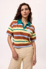 Remera tejida de algodón con cuello polo amarillo, corte boxy y estampado de rayas horizontales en tonos azul claro, marrón, rojo y amarillo.