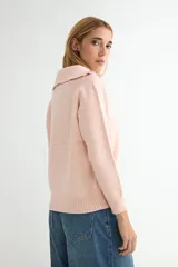 Buzo de punto gris con cuello polo y cierre frontal parcial, de manga larga y diseño holgado con puños y ruedo acanalados.