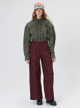 Pantalón sastrero de tiro medio y pierna ancha, color bordó con finas rayas verticales negras. Presenta costuras decorativas verticales en el frente y vivos en contraste que recorren la prenda.