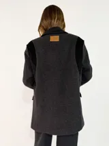 Tapado de paño de lana en color beige con detalles en pana marrón oscuro en hombros, cuello y bolsillos. Diseño de corte recto y estructura clásica.