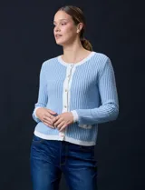 Cardigan de tejido tweed celeste y blanco, con escote redondo, cierre frontal con botones metálicos dorados y bolsillos simulados en el frente.