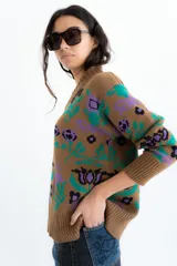 Buzo tejido de algodón negro con diseño jacquard de flores multicolor, cuello en V y mangas largas.