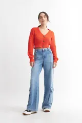 Cárdigan color borgoña de tejido de punto con textura acanalada, escote en V, cierre frontal con botones y mangas largas abullonadas.