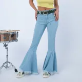 Jean de corte flare color celeste, con diseño ajustado en las piernas y botamangas acampanadas y deshilachadas. Presenta costuras verticales frontales y tiro medio.