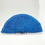 Bolso de mano azul tejido en abacá natural con forma de medialuna y cierre superior con cremallera.