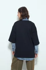 Remera blanca de manga corta con calce relajado y cuello a la base. Presenta un estampado frontal pequeño y una estampa protagonista en la espalda con el texto "Rocky Mountain National Park" y un paisaje de montañas y árboles.