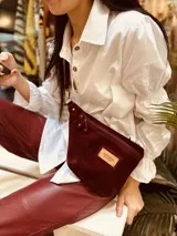 Riñonera de cuero con estampado animal print de vaca en blanco y negro, con correa regulable y cierre superior.