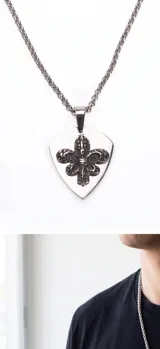 Collar de acero con cadena de eslabones trenzados y dije en forma de púa con diseño de flor de lis en relieve.