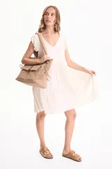 Vestido corto de viscosa color beige, sin mangas con volados en las sisas, escote en V y diseño escalonado.