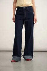 Pantalón de jean azul oscuro, de corte acampanado y tiro alto.