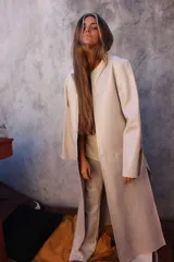 Tapado marrón de cuero con corte a la rodilla, mangas largas y aberturas laterales.