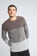 Sweater de punto con diseño de bloques de color en tonos gris, marrón y gris claro. Presenta cuello redondo, mangas largas y puños acanalados.