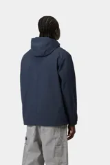 Campera impermeable estilo anorak Carhartt WIP modelo Windbreaker Pullover, color azul marino, con capucha ajustable, cierre frontal de media cremallera y bolsillo canguro frontal con solapa.