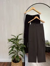 Pantalón negro de corte sastrero con bolsillos cargo laterales, tiro alto y corte recto.