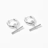 Aros plateados de acero con forma de argolla y dije colgante en forma de barra horizontal.