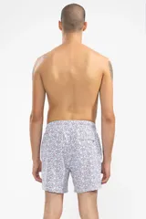Short de baño blanco con estampado de lunares azules y naranjas. Cuenta con cintura elástica con cordón regulable, bolsillos laterales y bolsillo trasero con cierre.