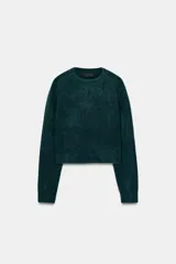 Jersey de punto suave con cuello redondo y manga larga, con terminaciones en rib en puños, cuello y ruedo.