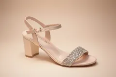 Sandalias de fiesta color beige con acabado satinado, tacón cuadrado medio y tira frontal decorada con pedrería brillante. Cuenta con pulsera al tobillo con cierre de hebilla metálica.