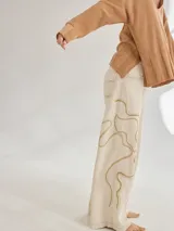 Pantalon de corte recto y tiro medio, color beige, con bordados artesanales en hilo que simulan vetas. Confeccionado en una mezcla de algodón, viscosa y lino.