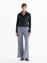 Camisa de jacquard con diseño de flores sutiles, color blanco, con cuello amplio de puntas marcadas, mangas largas con puños y cierre frontal con botones.