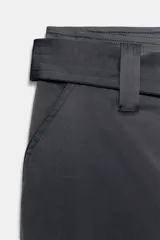 Pantalón cargo de tiro medio confeccionado en tejido satinado. Presenta bolsillos laterales con solapa, corte recto y holgado, y un cinturón integrado del mismo tejido con hebilla metálica.