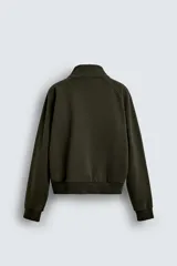 Sudadera de algodón con interior en rizo afelpado, cuello subido, manga larga y cierre frontal de cremallera. Presenta un efecto lavado que le da una apariencia única y bolsillos frontales ocultos en las costuras.