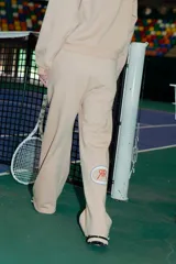 Pantalón de jogging recto color camel, confeccionado en frisa. Tiene bolsillos laterales, cintura elastizada y puño estampado en la botamanga trasera con el isologo de Renée.