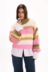 Buzo de tejido de punto grueso con diseño de rayas horizontales en colores crema, rosa, verde oliva y tostado. Presenta cuello redondo, mangas largas con puños ajustados y corte holgado.