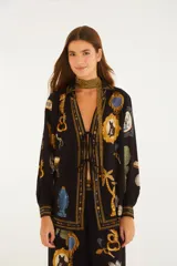 Blusa negra de viscosa con mangas largas y puños ajustables, escote en V con lazos frontales y silueta fluida, con estampado artístico de marcos, animales y elementos marinos.