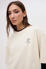 Remera de algodón lavado color beige, de manga corta y calce clásico, con pequeño bordado de estrella en el pecho.