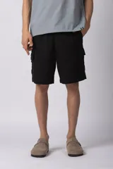 Bermuda cargo de lino y rayón color blanco, con bolsillos laterales tipo cargo, cintura elástica con cordón ajustable y calce relajado.