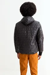 Campera puffer negra con capucha, cierre frontal completo y puños elásticos. Diseño acolchado con costuras horizontales.