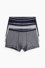 Pack de tres calzoncillos tipo trunk cortos, confeccionados en punto elástico de algodón. Incluye un par a rayas azul marino y blanco, uno gris liso y uno azul marino liso. Todos con cintura elástica y costuras planas.