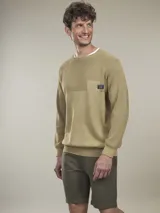 Sweater de algodón con cuello redondo, diseño de tejido combinado con textura acanalada en la parte superior y bolsillo frontal pequeño con etiqueta decorativa.