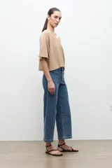 Jean culotte de corte ancho y tiro medio, en tono azul medio, con bolsillos aplicados en el frente.