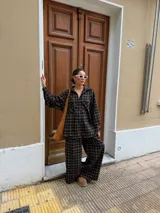 Pantalón de corte recto y holgado, confeccionado en tela de viyela con estampado de cuadros en tonos negro, gris y blanco. Presenta cintura elástica para mayor comodidad.