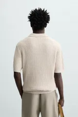 Polo de punto con textura acanalada, cuello solapa con abertura frontal y manga corta. Presenta un diseño de calce regular con terminaciones en rib.