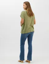 Blusa de corte fluido confeccionada en algodón con tejido texturizado de patrón a cuadros. Presenta mangas cortas caídas, escote redondo y cierre frontal con botones.
