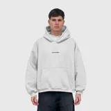 Hoodie oversize de felpa color gris claro, con capucha y bolsillo frontal tipo canguro. Presenta un bordado central en color negro con el texto 'venelo'.