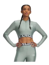 Remera de entrenamiento Under Armour de manga larga con cierre frontal de un cuarto. Presenta un diseño cropped con banda elástica inferior visible con el logo de la marca, cuello alto y orificios para los pulgares en los puños.