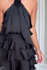 Top color beige claro con escote halter y tres volados. Incluye una rosa de tela removible en el cuello.