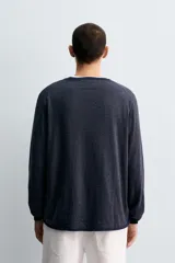 Jersey de punto con diseño de rayas horizontales finas, cuello redondo y manga larga. Presenta un corte regular fit con terminaciones en rib en cuello, puños y ruedo.