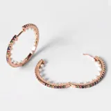 Aros tipo argolla de acero con baño de oro rosa de 18k, con cristales de colores en el exterior y perlas en el interior.