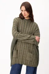 Sweater de tejido artesanal con diseño de rayas verticales en tonos camel y beige, corte holgado, cuello redondo y puños altos ajustados.