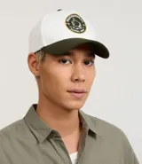 Gorra de algodón color blanco con visera curva y ajuste de hebilla de cuero marrón. Presenta bordado frontal con letras "Pagodinho F.C." en dorado.