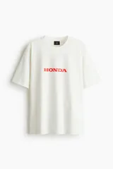 Remera de algodón color blanco con cuello redondo y estampado frontal con el logo de Honda en color rojo.