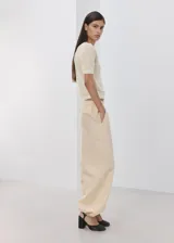 Chaleco de punto fino calado color beige, con cuello redondo y mangas cortas.