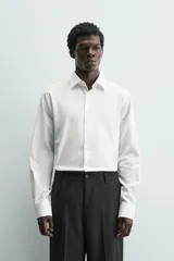Camisa de corte relajado confeccionada en tejido fluido de lyocell. Presenta cuello solapa, manga larga con puños abotonados y cierre frontal con botones.